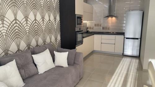 Объединенное пространство кухни - гостиной со столовой зоной в бежевых тонах с золотистыми элементами. 02