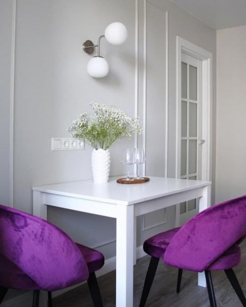 Меблировка обеденной зоны яркими цветными стульями в белом интерьере кухни. 03