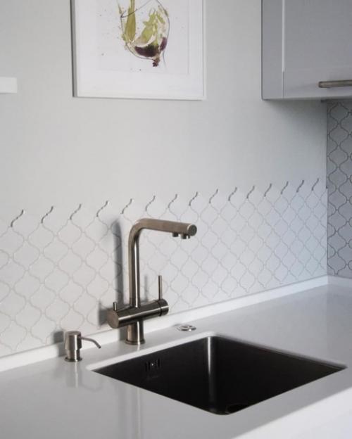 Меблировка обеденной зоны яркими цветными стульями в белом интерьере кухни. 02