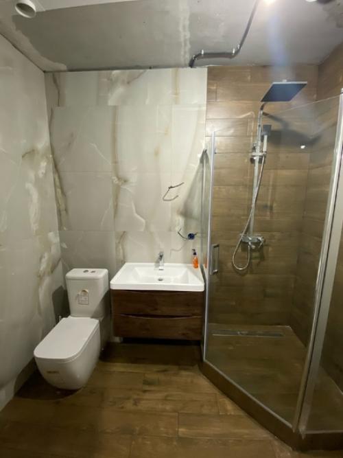 Нeдодeланная ванная комната, нeт потолка, стeллажа и зeркала с машинкой.